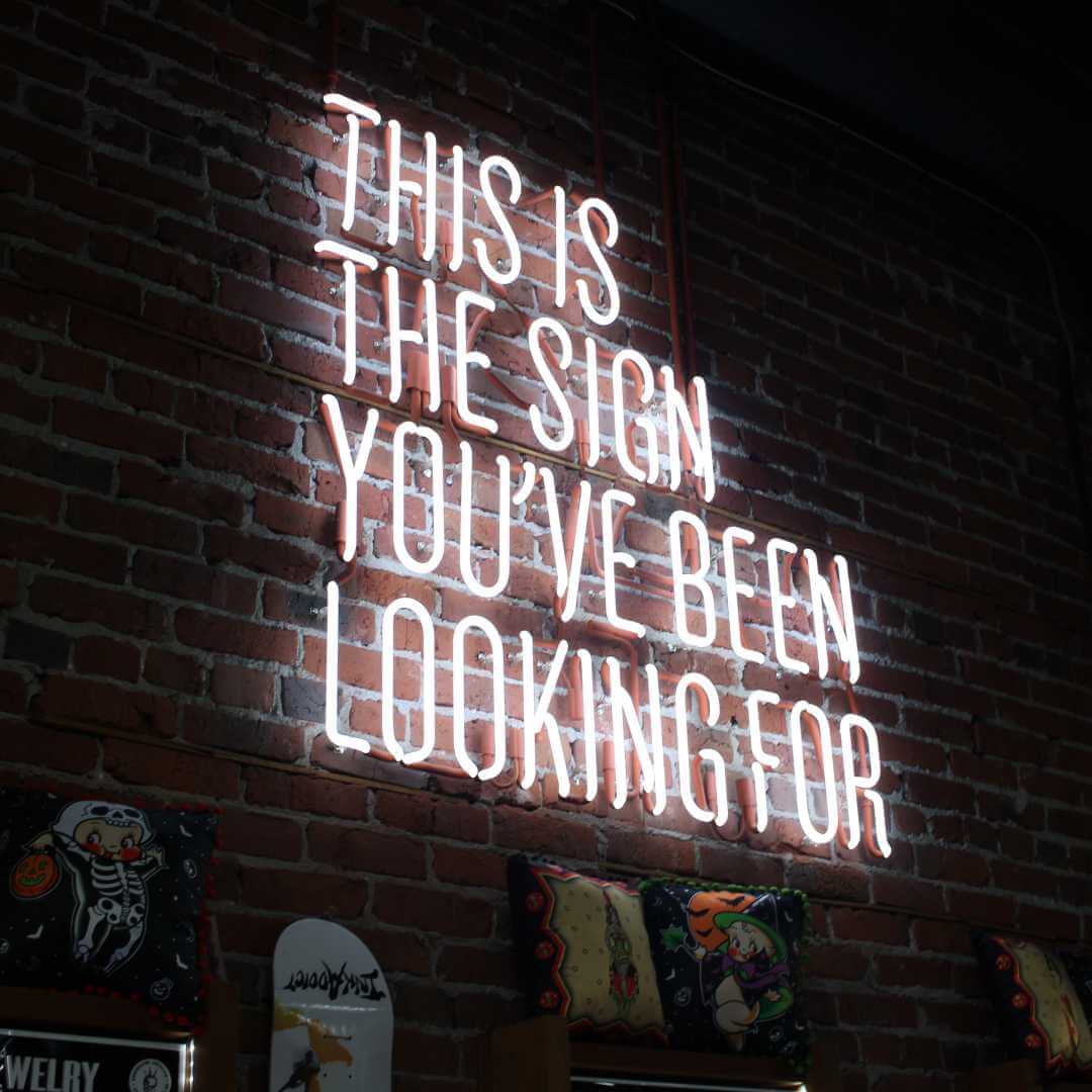 A brick wall with a neon sign