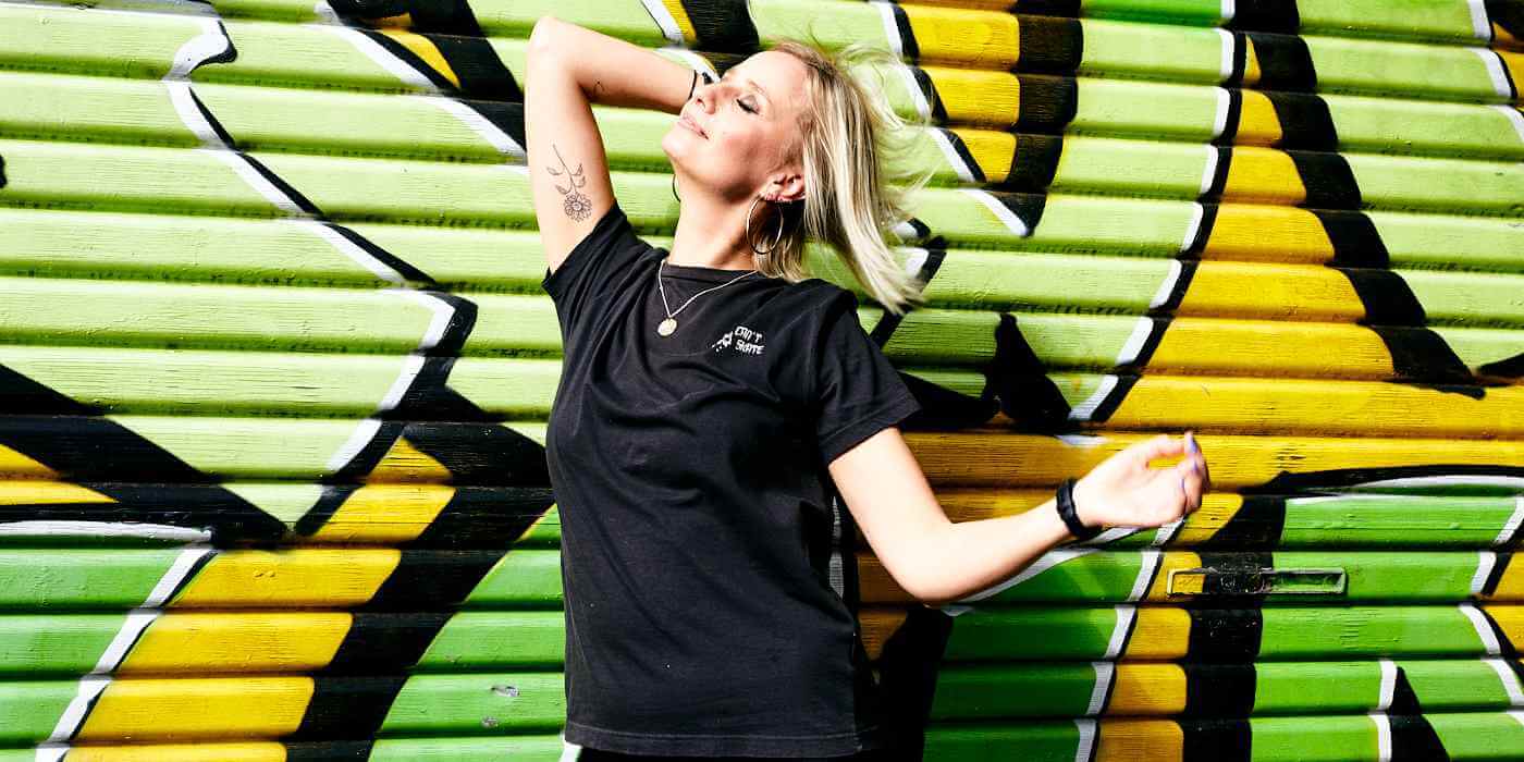 Cat Dunn standing in front a a green and yellow painted garage door