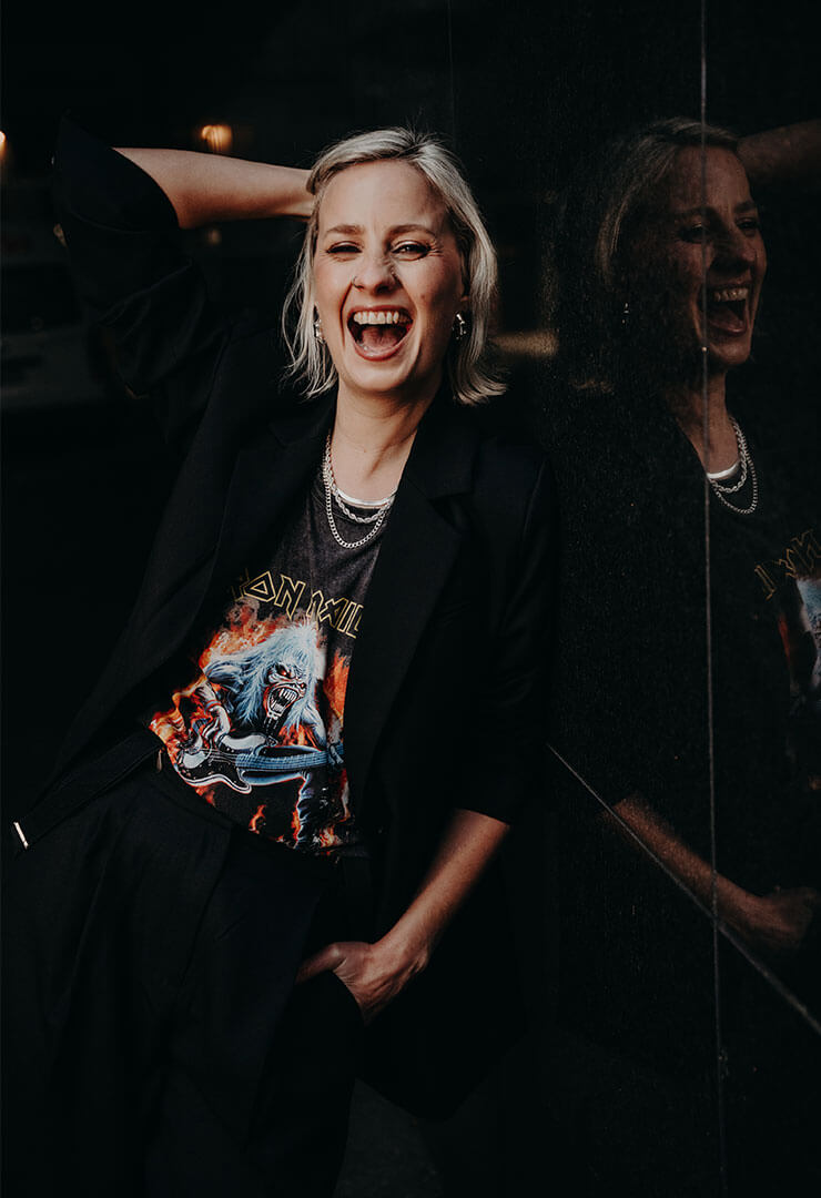 Cat Dunn laughing at the camera wearing an iron maiden shirt.